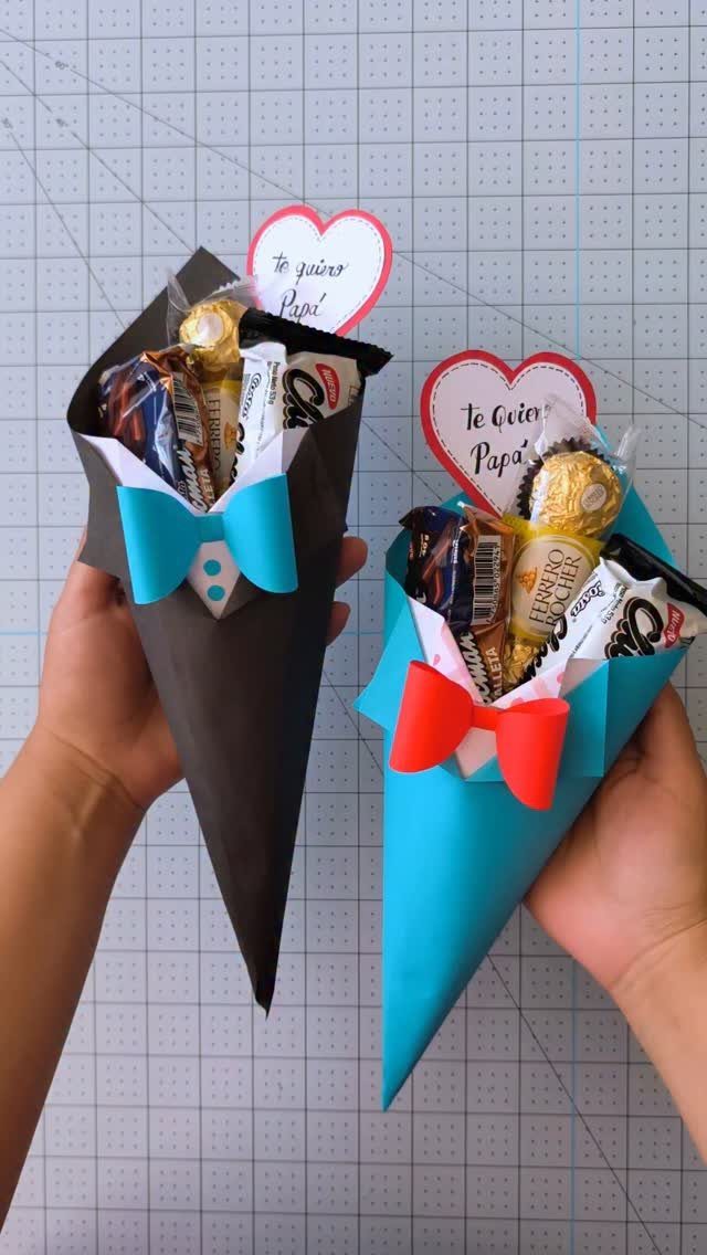 Two candy-filled paper cones shaped like tuxedos with bow ties and heart tags.