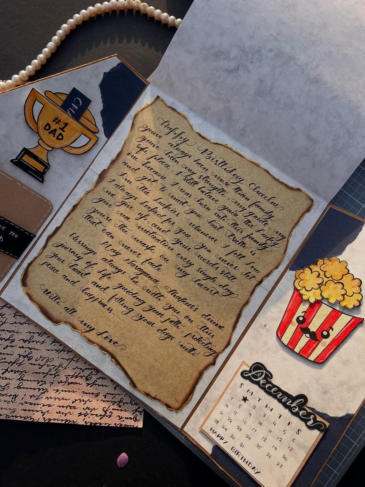Handmade scrapbook with a handwritten letter and a #1 Dad trophy sticker.