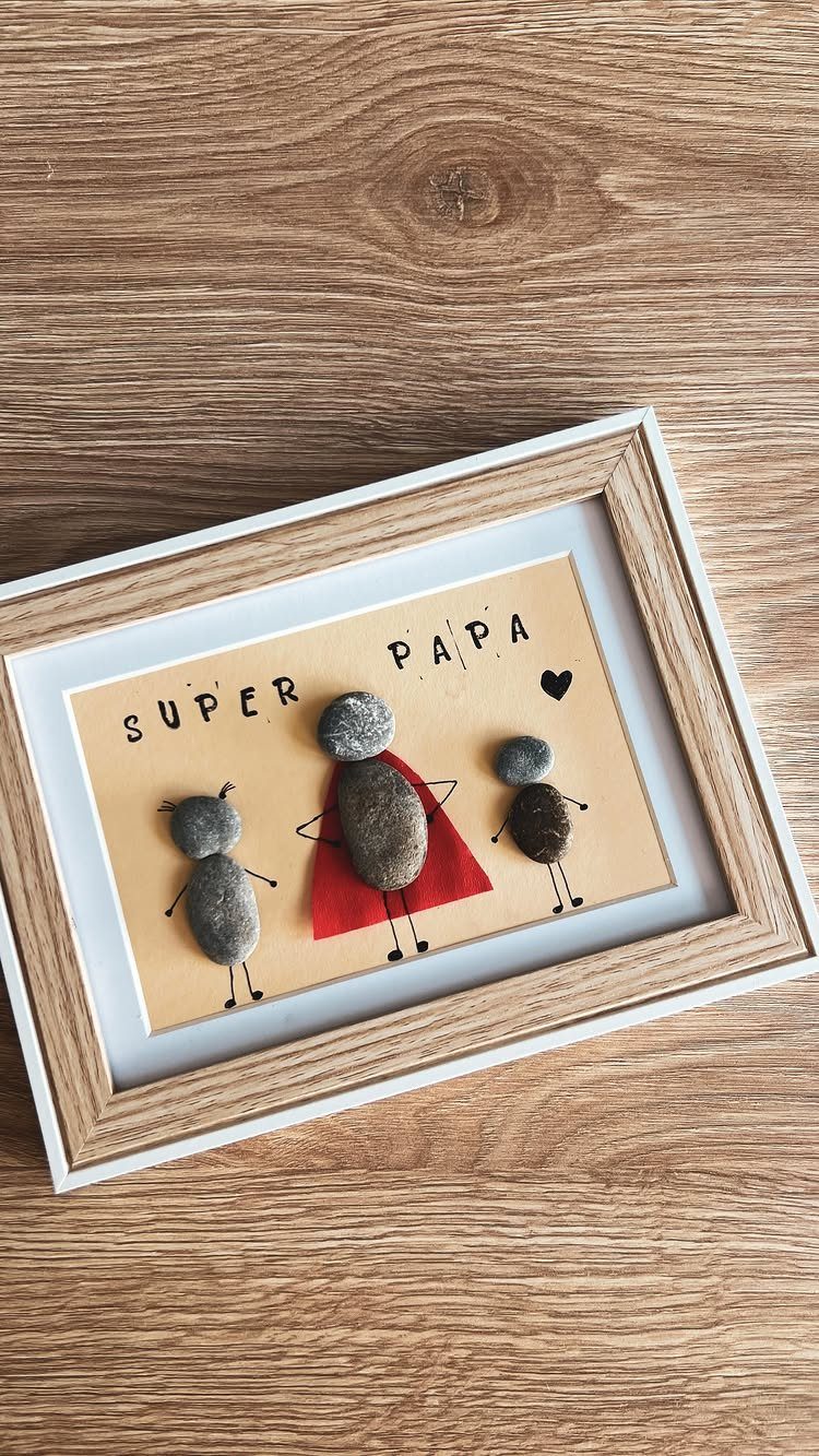 Framed stone art of a family with a red cape and Super Papa text.