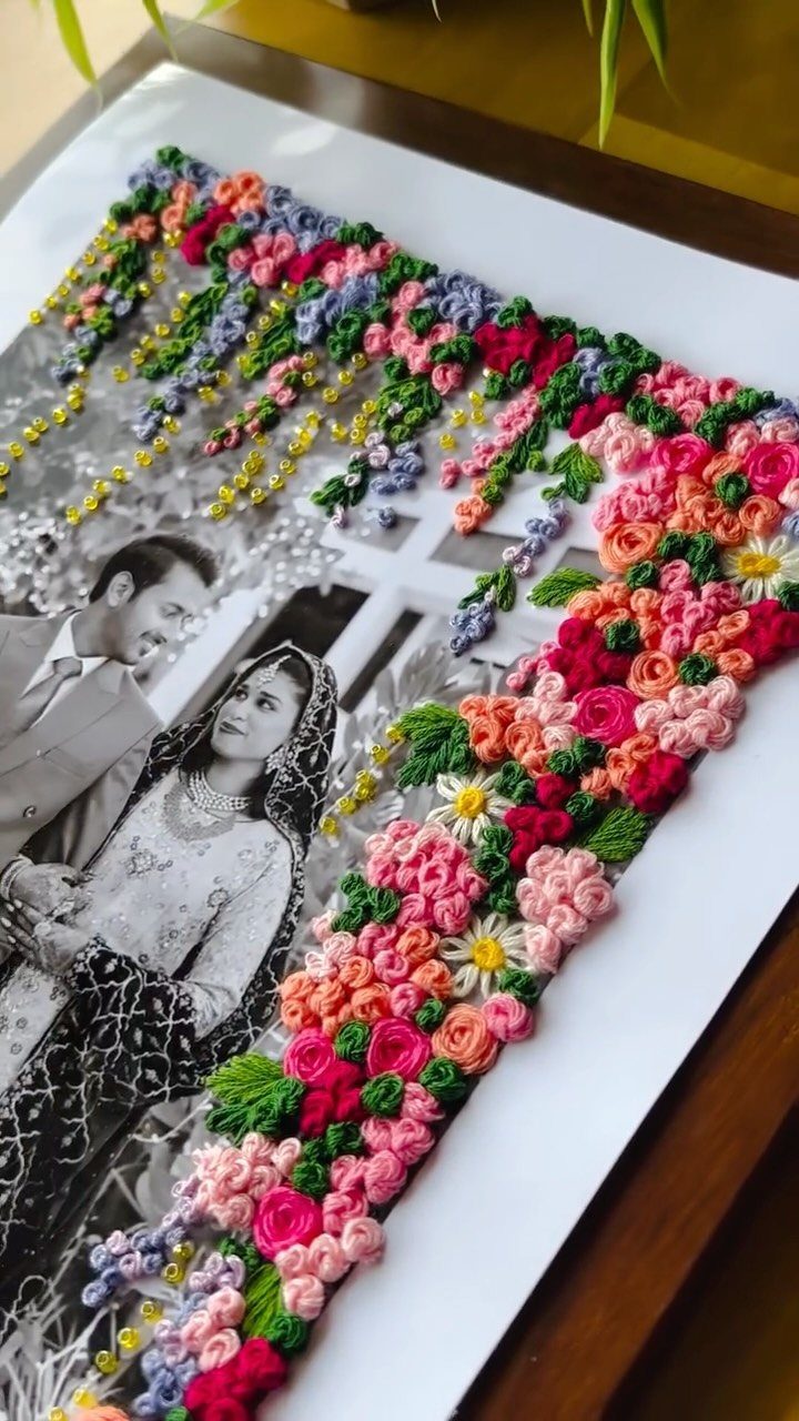 Black and white couple portrait with a colorful 3D embroidered floral yarn border.