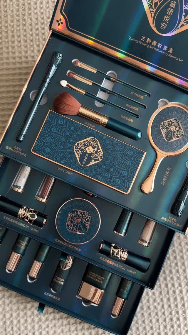 Luxury teal and gold makeup set with brushes and cosmetics in a box.