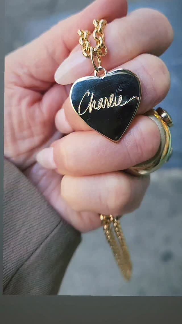 Gold heart pendant with black center featuring the name Charlie in cursive script