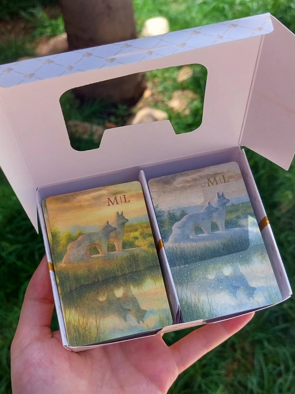 Two custom decks of cards with wolf artwork inside a white gift box.