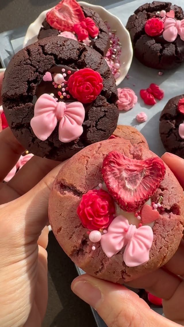 Decorated chocolate and pink cookies with frosting bows and fresh strawberry slices.