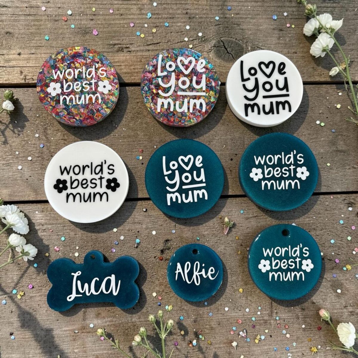Resin tokens with Mother's Day messages and names on a wooden background.
