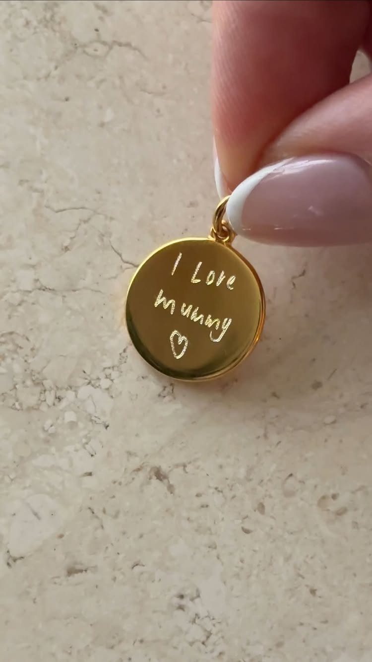Gold circular pendant engraved with I Love mummy and a heart.