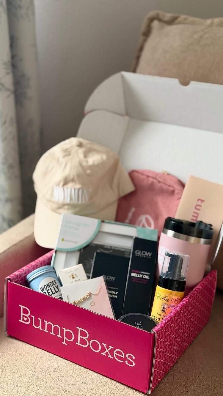 Pink BumpBoxes gift box containing a beige cap, belly oil, and pink tumbler.