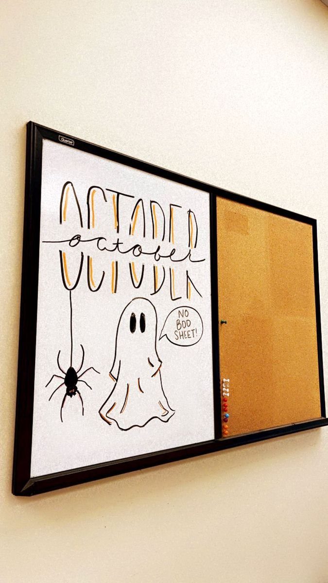 White board with October lettering, a ghost drawing, and a spider on a wall