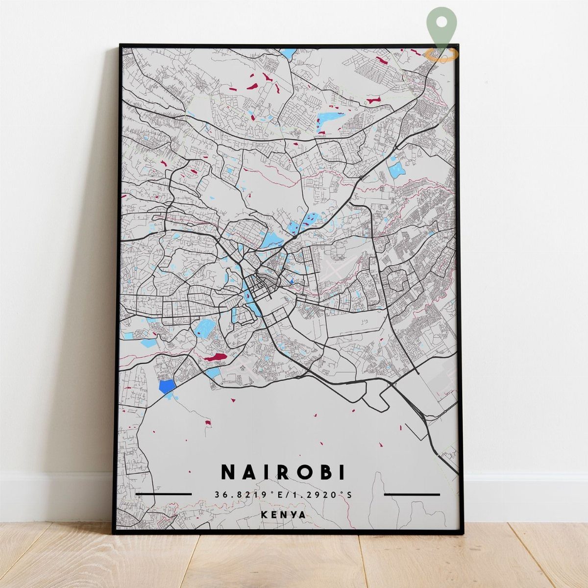 Framed map poster of Nairobi, Kenya, leaning against a white wall on wood flooring.