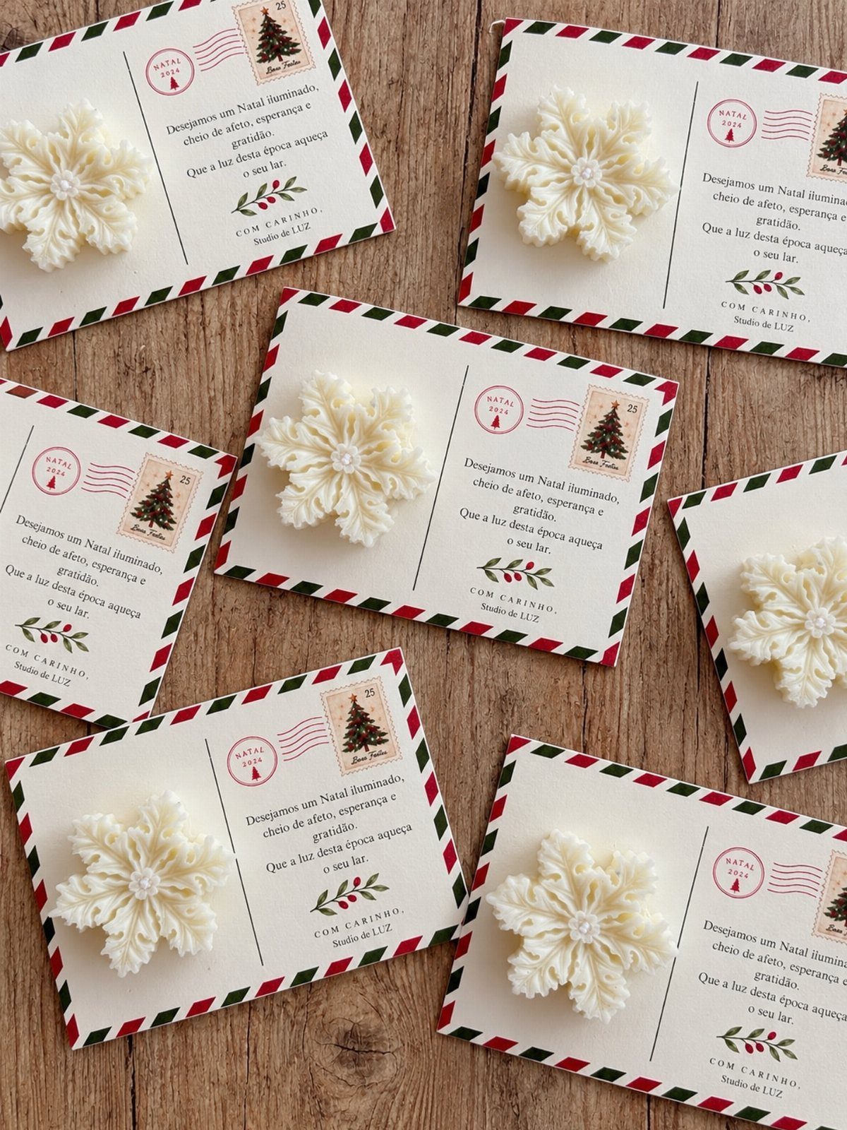 White crocheted snowflakes attached to festive holiday greeting cards on a wooden table.