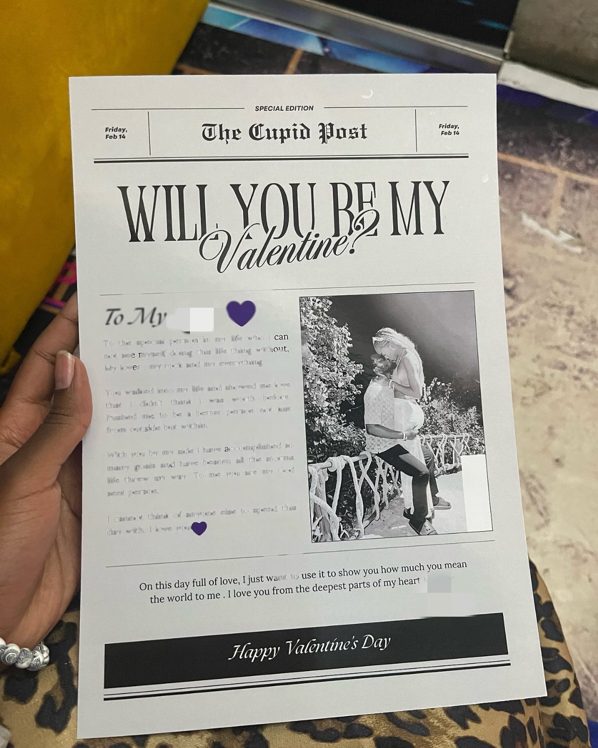 The Cupid Post newspaper held by a hand, featuring a romantic Valentine's proposal.