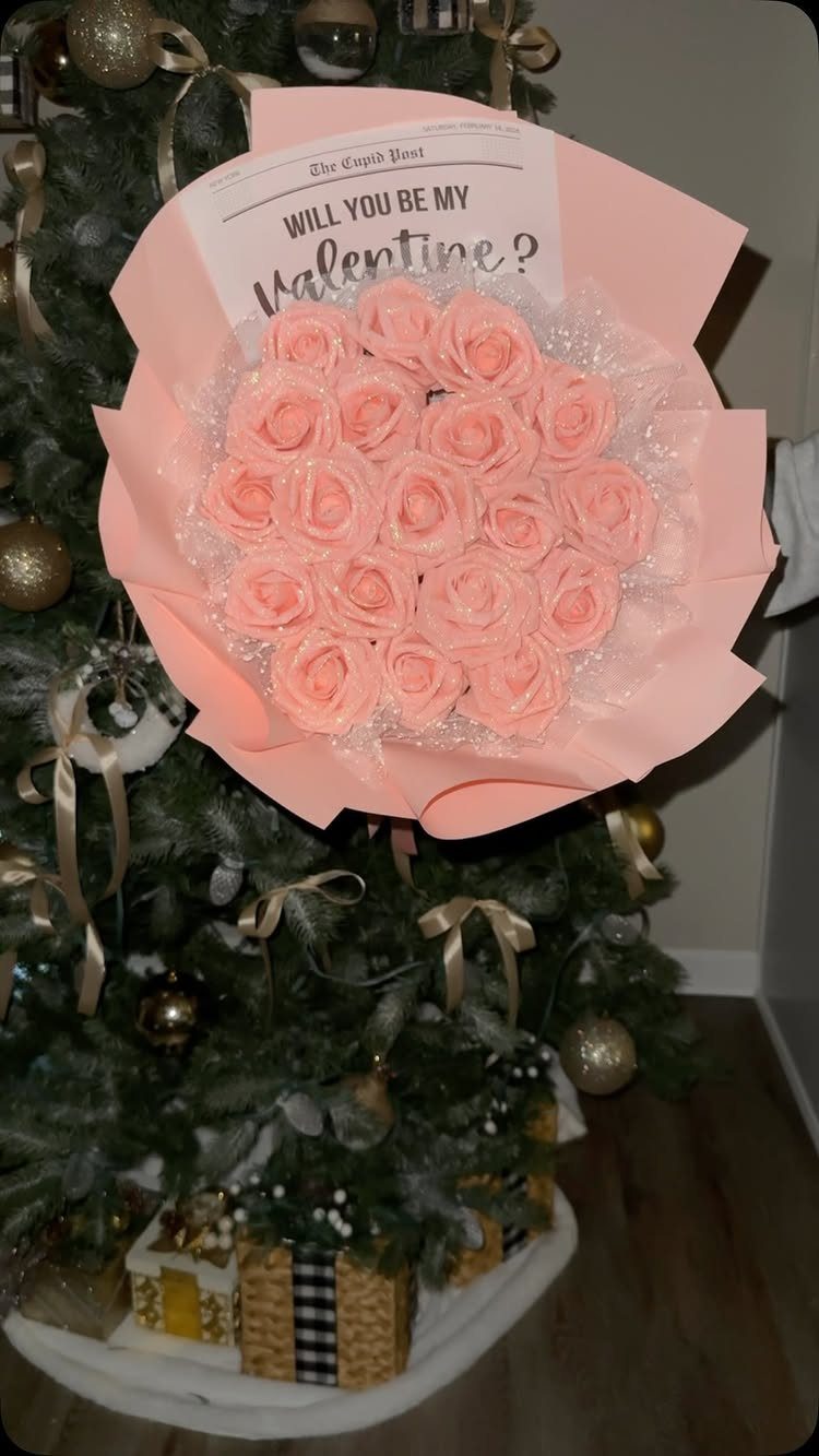 Pink rose bouquet wrapped in pink paper with a Valentine's newspaper card.