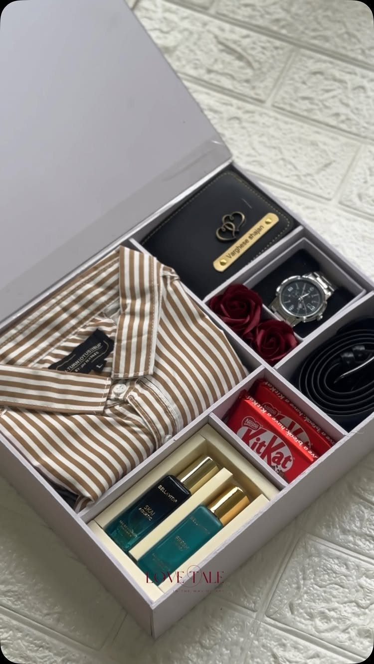 Gift box with striped shirt, watch, wallet, belt, fragrance bottles, and chocolate.