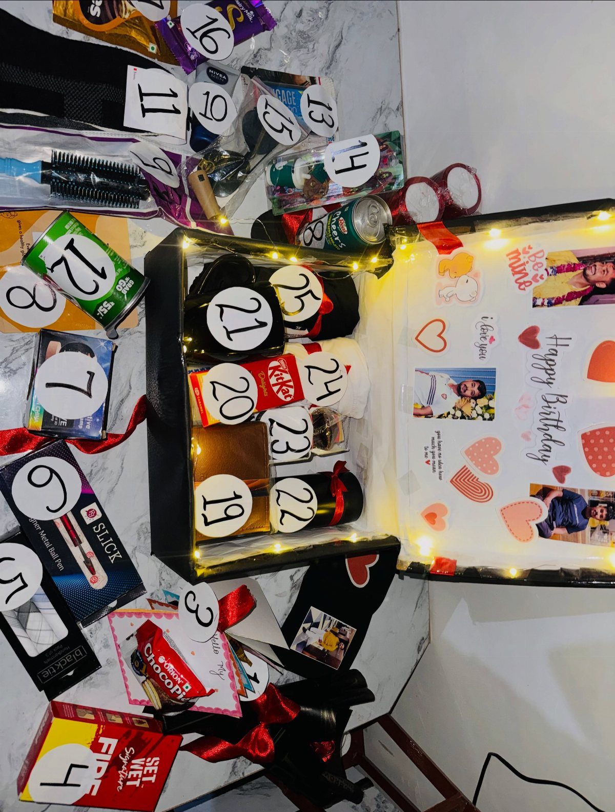 Numbered birthday gift box and surrounding presents for a man on marble surface