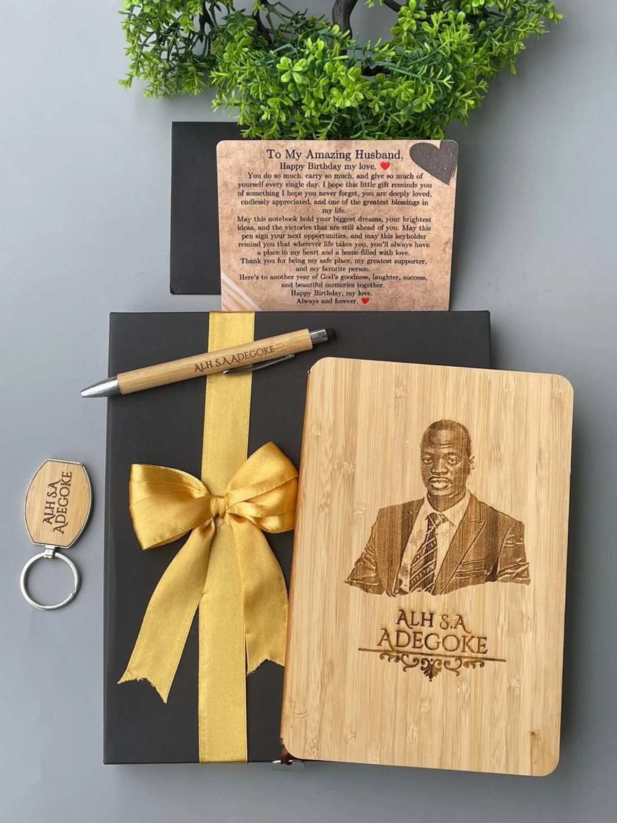 Personalized wooden gift set with engraved portrait, message plaque, pen, and gold ribbon.