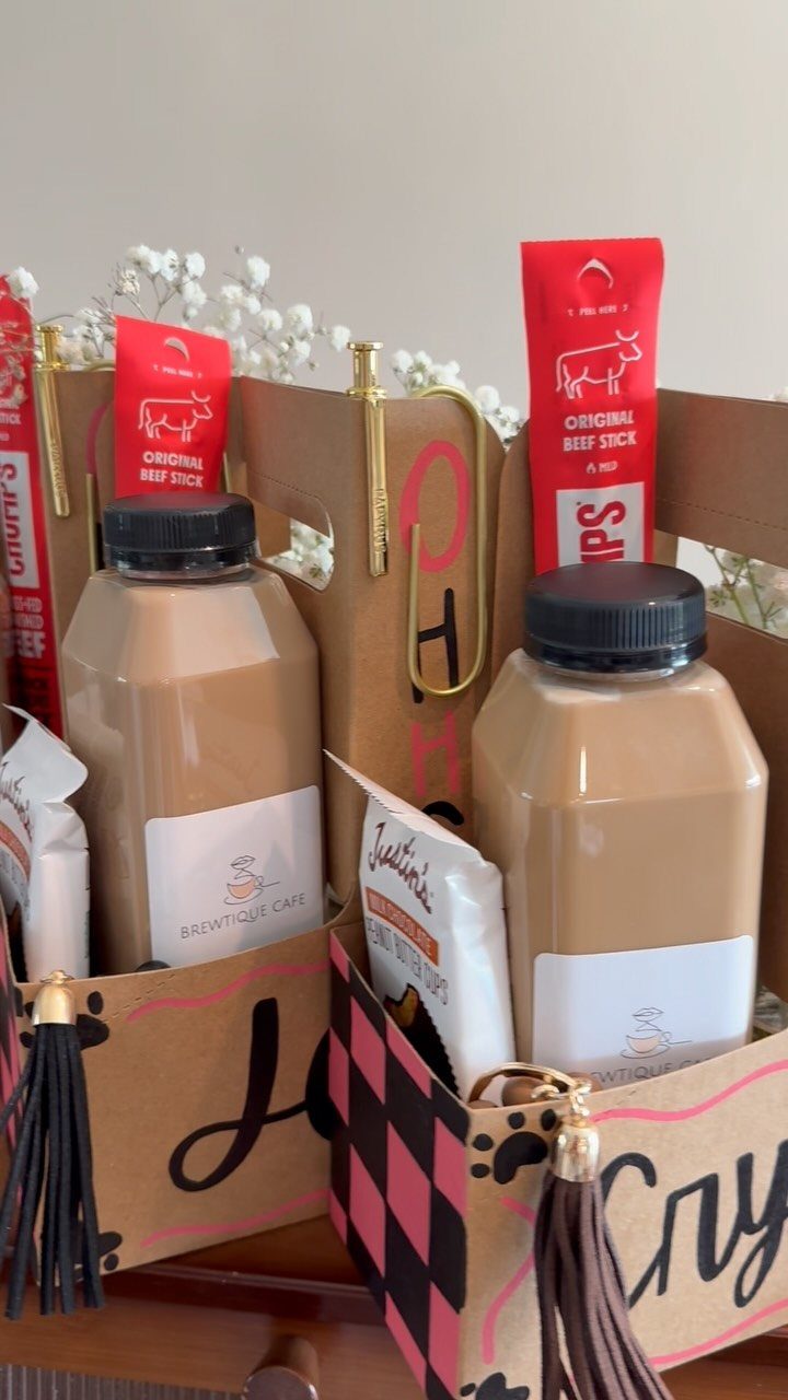 Gift boxes containing brown bottled drinks, red beef sticks, and white snack bags.