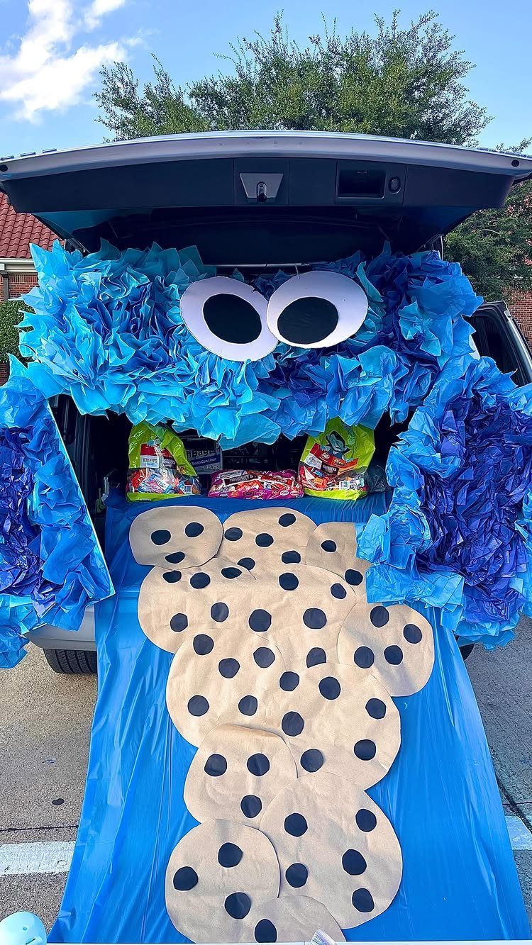 Cookie Monster themed car trunk decoration with blue ruffles and cardboard cookies.