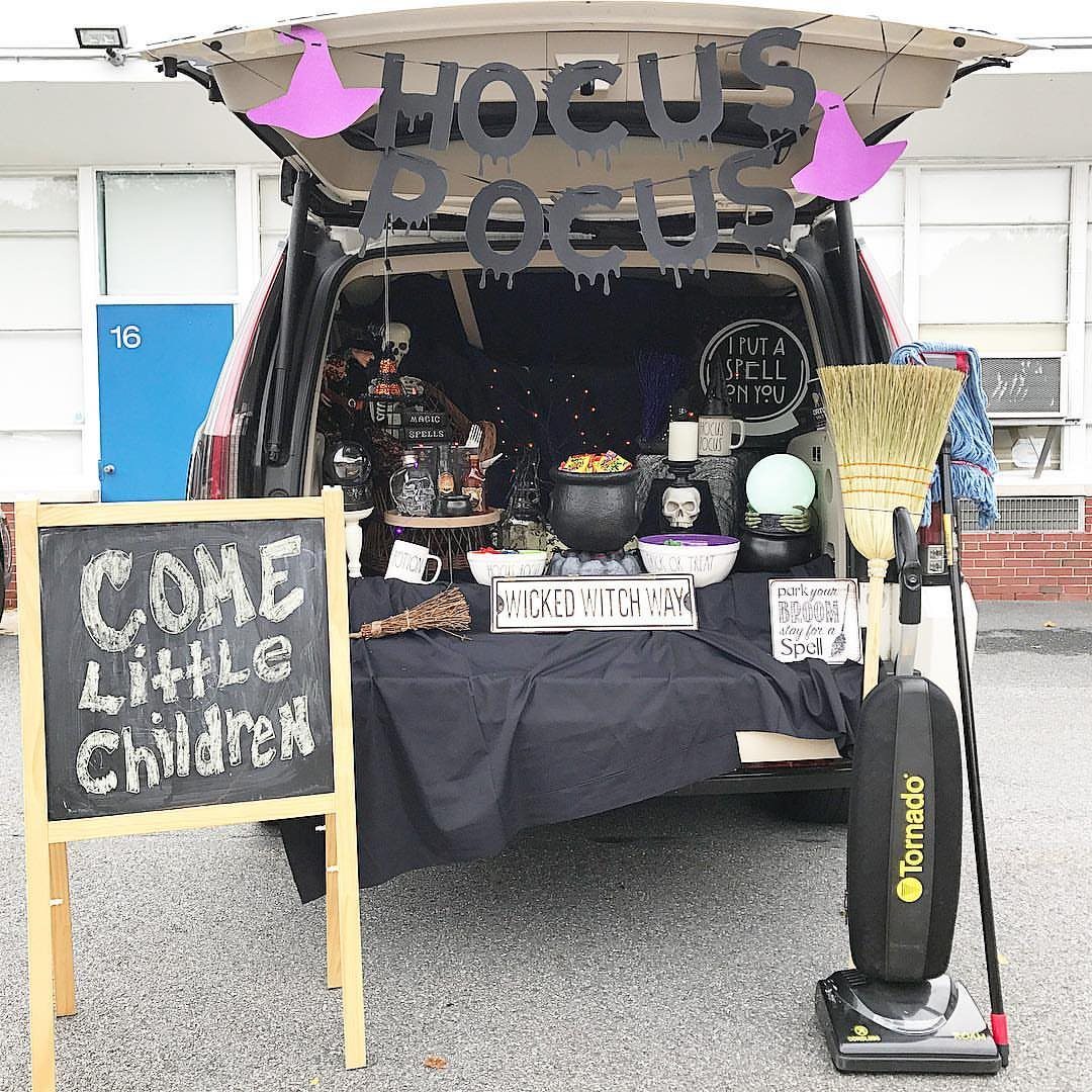 Hocus Pocus themed car trunk decoration with witch hats, cauldron, and chalkboard sign.