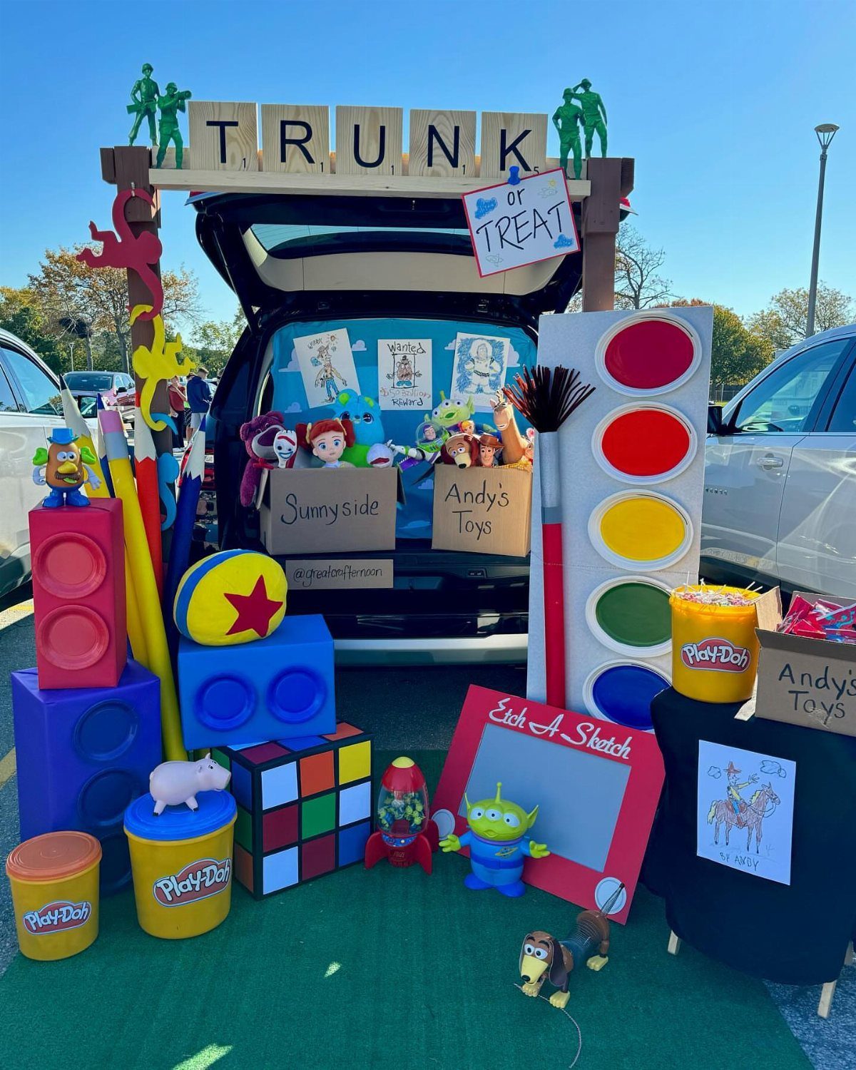 Toy Story themed car trunk decoration with giant blocks, crayons, and character toys.