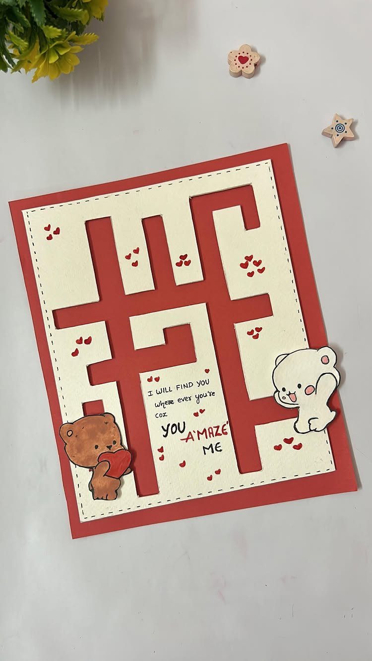 Handmade Valentine's Day card with a red paper maze and cute bear figures.