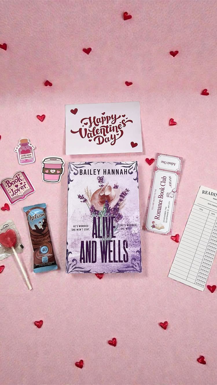 Valentine's Day gift set with a book, chocolate, and card on pink background