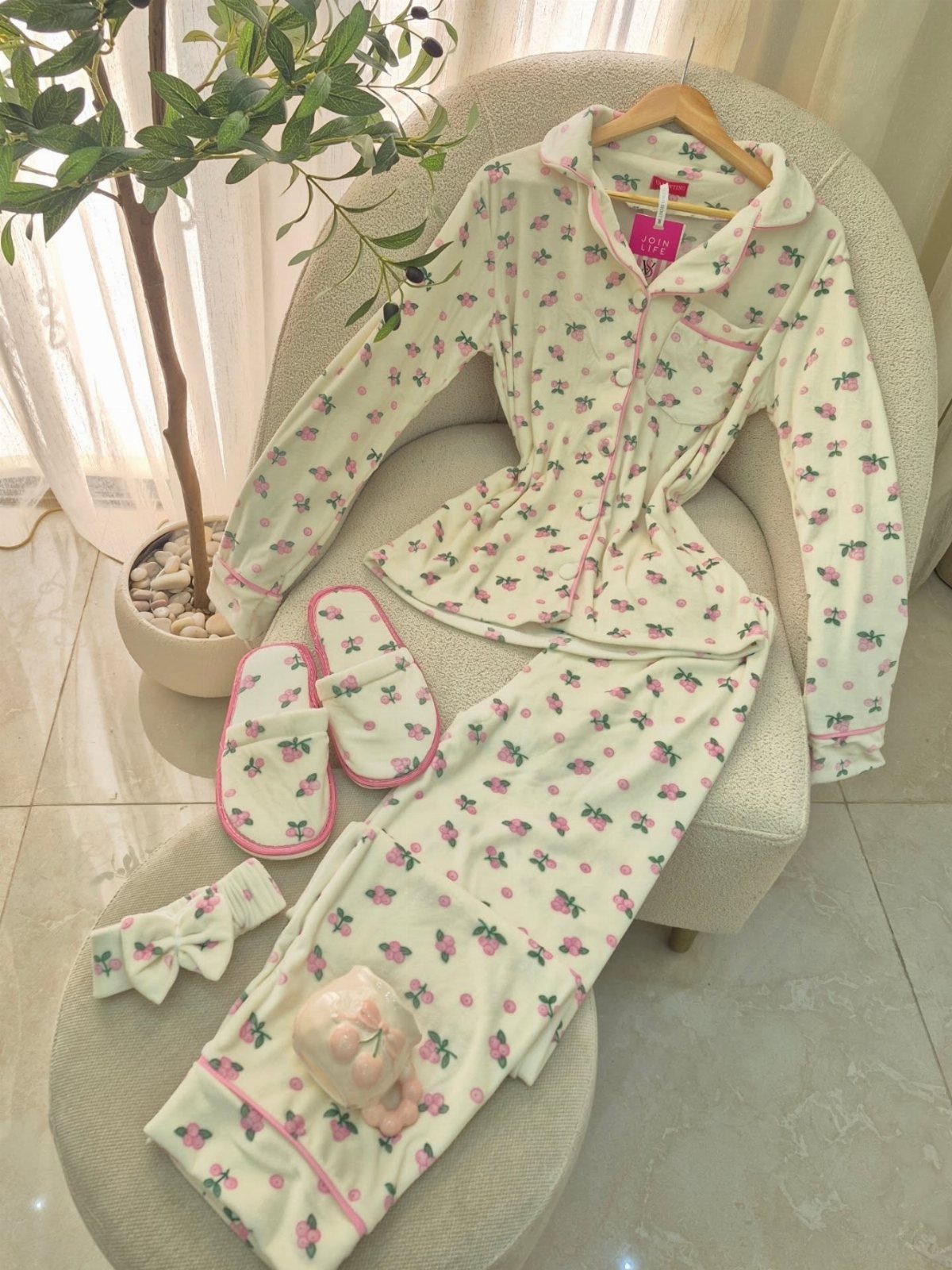 Cream floral fleece pajama set with matching slippers and bow on a chair