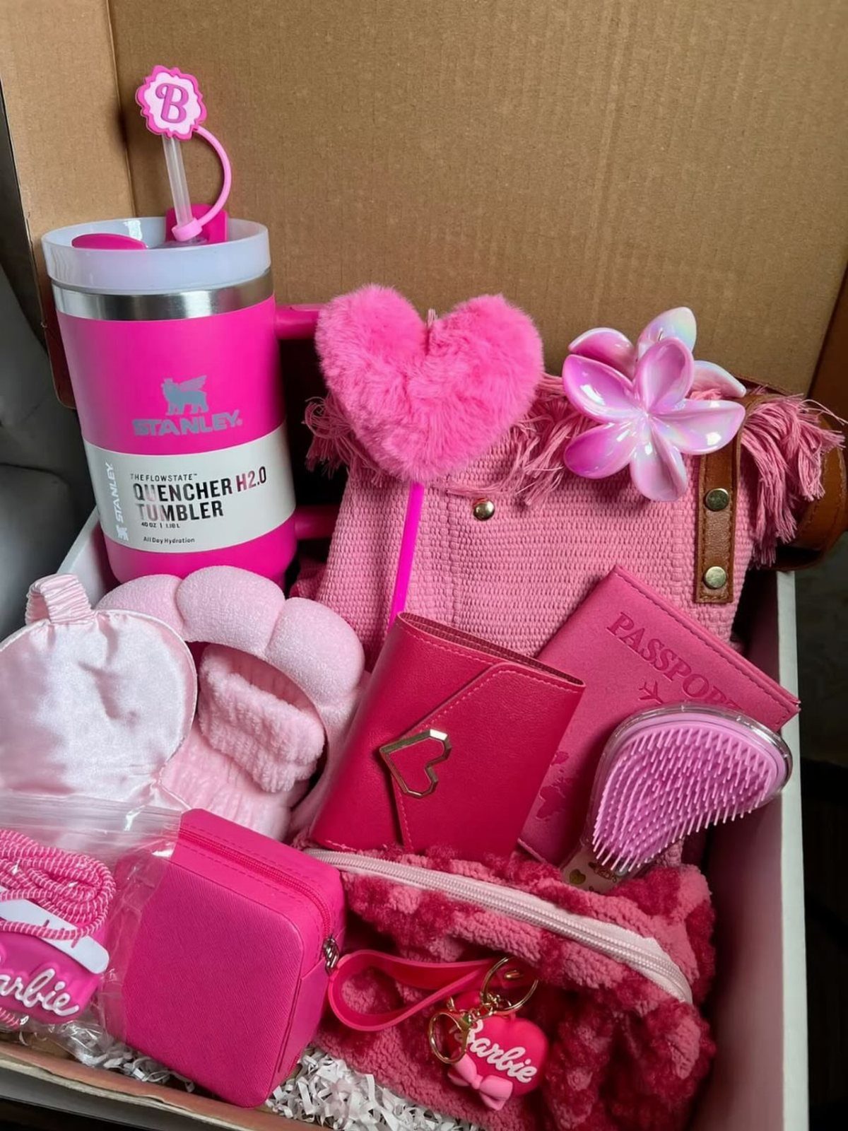 Pink themed gift box containing a Stanley tumbler, handbag, wallet, and plush accessories.