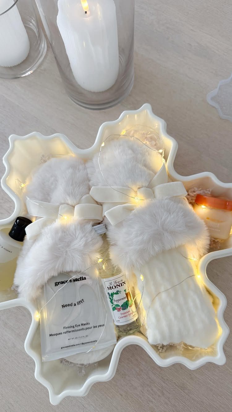 White fluffy slippers and spa products in a snowflake tray with fairy lights.