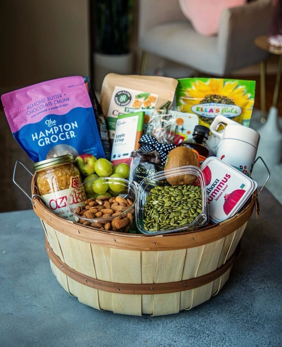 Gourmet food basket filled with snacks, nuts, fruit, and a white mug.